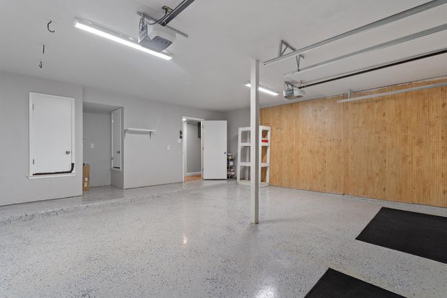 Garage featuring a garage door opener and wood walls | Image 38