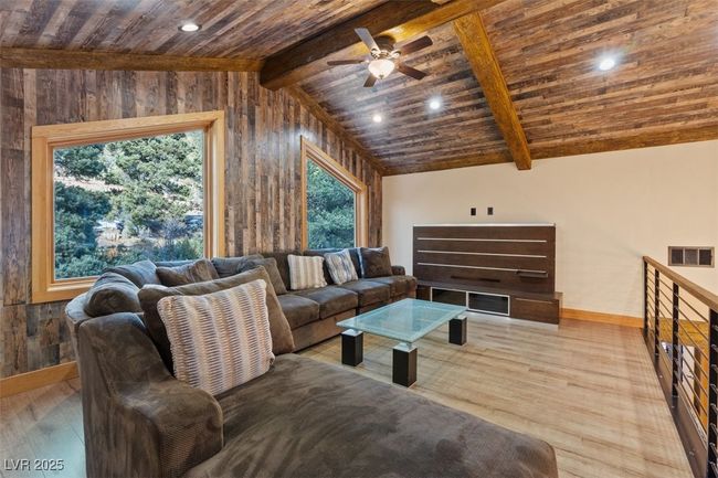 Living room featuring vaulted ceiling with beams, wooden ceiling, wood finished floors, visible vents, and baseboards | Image 17