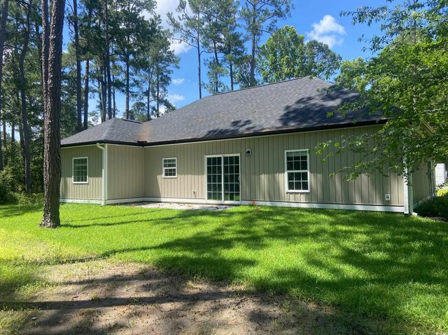 Back of house featuring roof with shingles and a lawn | Image 6