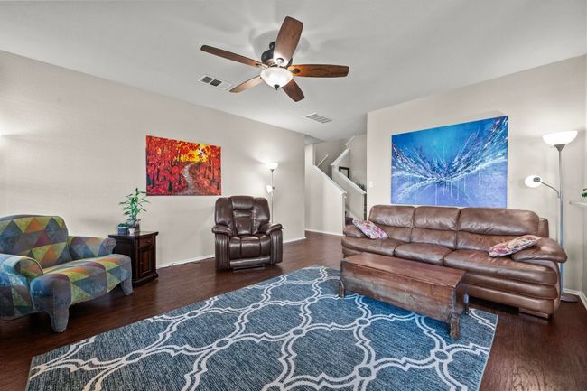 The living room includes a ceiling fan with easy access to the staircase leading to the 2nd level. | Image 5