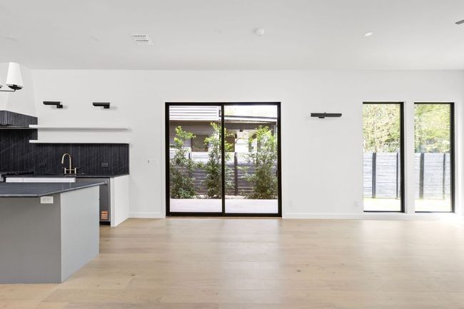 Kitchen with dark countertops, healthy amount of natural light, backsplash, and light wood-type flooring | Image 14