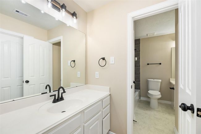 This well-designed bathroom features a spacious vanity area offering ample counter space and a large mirror. | Image 31