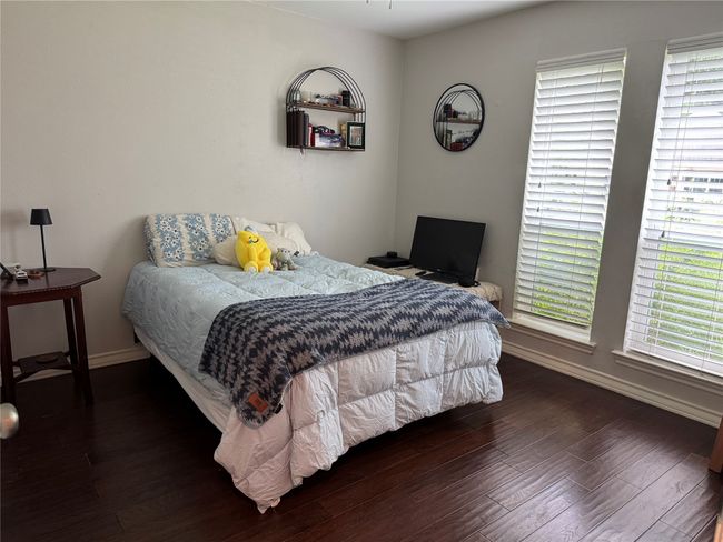Bedroom featuring wood finished floors, baseboards, and multiple windows | Image 24