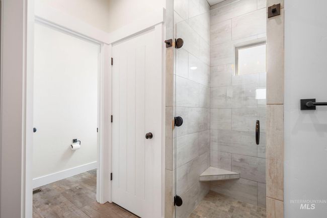 Bathroom featuring a shower stall and wood finished floors | Image 17