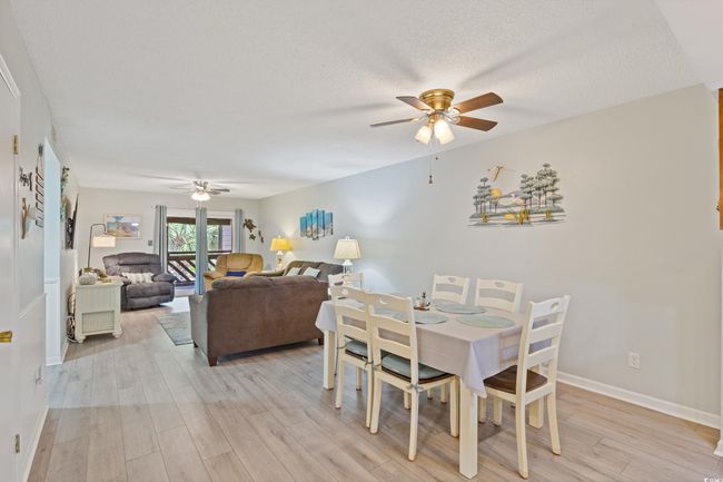 Dining room with baseboards, light wood-style flooring, and ceiling fan | Image 10
