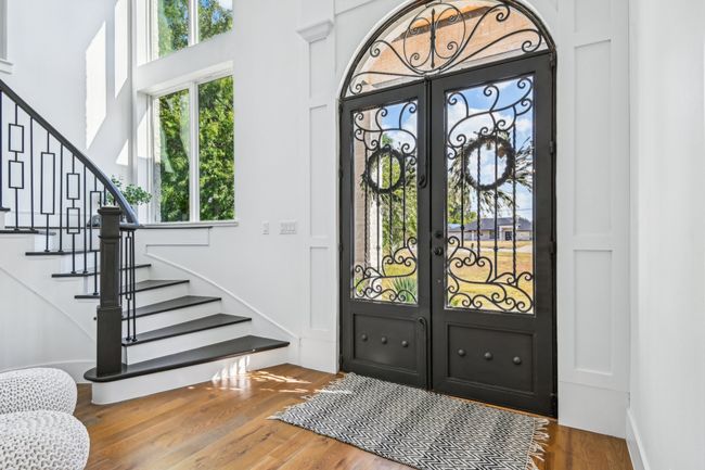 Entryway with stairway, french doors, wood finished floors, and a high ceiling | Image 6