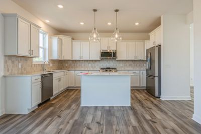 (Photo is of an inventory home, actual homes finishes will vary) Welcome to the Springfield! This spacious kitchen features a large center island, LVP floors, stainless appliances and more. | Image 2