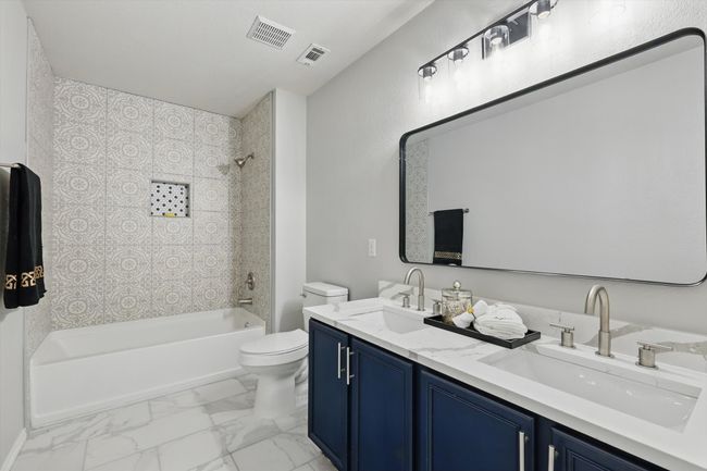 Bathroom with shower / bathtub combination, double vanity, and marble finish flooring | Image 16