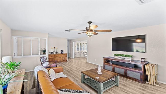Living room with light wood-style flooring, ceiling fan, baseboards, and visible vents | Image 28