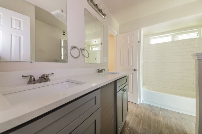 Full bath featuring double vanity, shower / bath combination, and wood finished floors | Image 24
