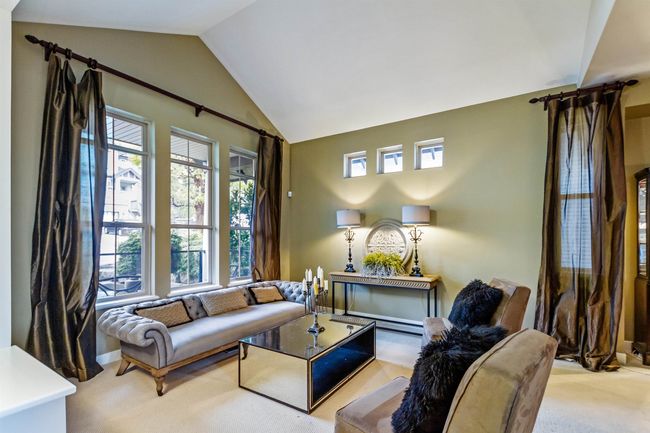 Carpeted living area with a healthy amount of sunlight and vaulted ceiling | Image 4