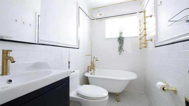Bathroom featuring tile walls, a freestanding bath, vanity, toilet, and tile patterned floors | Image 10