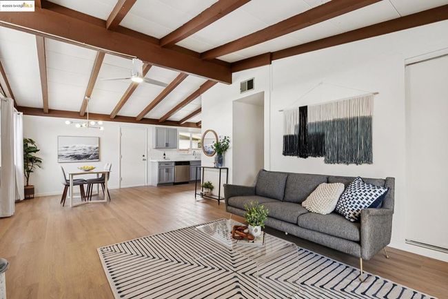Cozy living room with exposed beam ceiling and a classic brick fireplace | Image 4