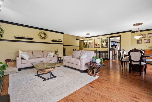 Living room featuring crown molding, a chandelier, and wood finished floors | Image 4