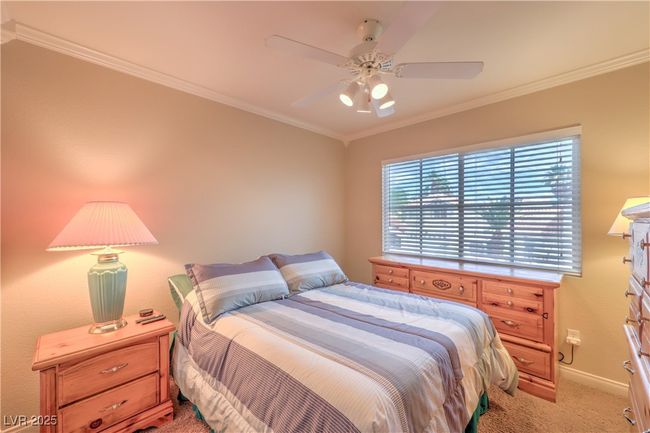 Bedroom with light colored carpet, crown molding, and ceiling fan | Image 10