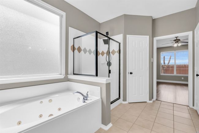 Primary bathroom featuring a soaking tub and shower. | Image 17