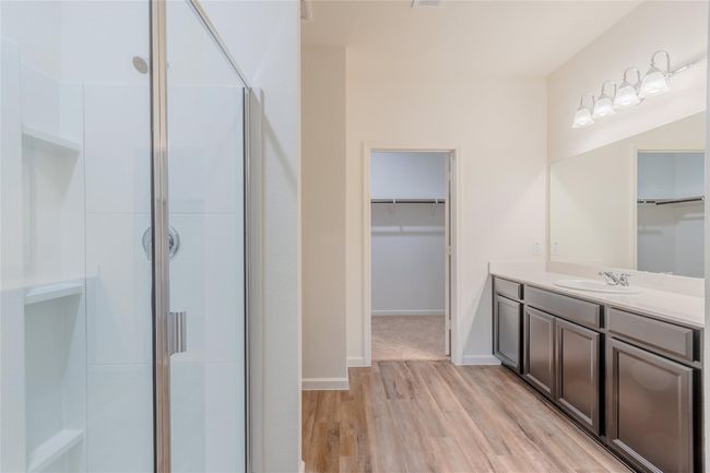 Bathroom featuring a stall shower, wood finished floors, a spacious closet, and vanity | Image 15