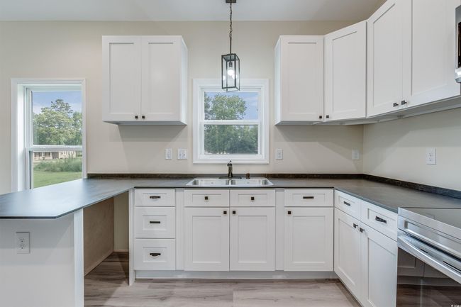 Kitchen featuring a sink, white cabinetry, and range | Image 10