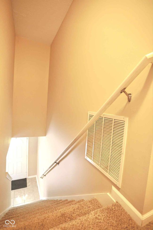 stairway with visible vents, tile patterned flooring, and baseboards | Image 25