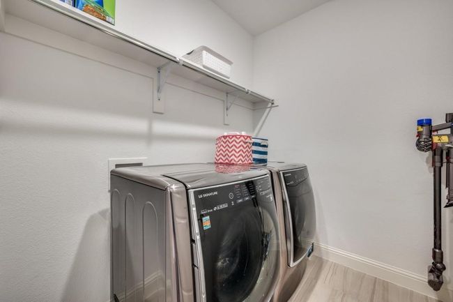 Laundry room featuring washing machine and dryer, baseboards, and light wood-type flooring | Image 33