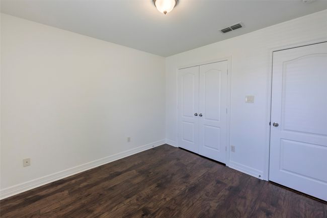 Unfurnished bedroom featuring baseboards, visible vents, a closet, and dark wood finished floors | Image 30