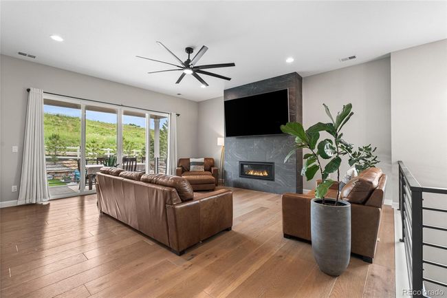 Floor to ceiling tiled fireplace, upgraded ceiling fan, white oak engineered hardwood floors - 12' sliding glass doors to outdoor patio/dining area | Image 9