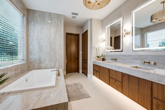 Full bathroom featuring healthy amount of natural light, a jetted tub, double vanity, and tile patterned flooring | Image 16