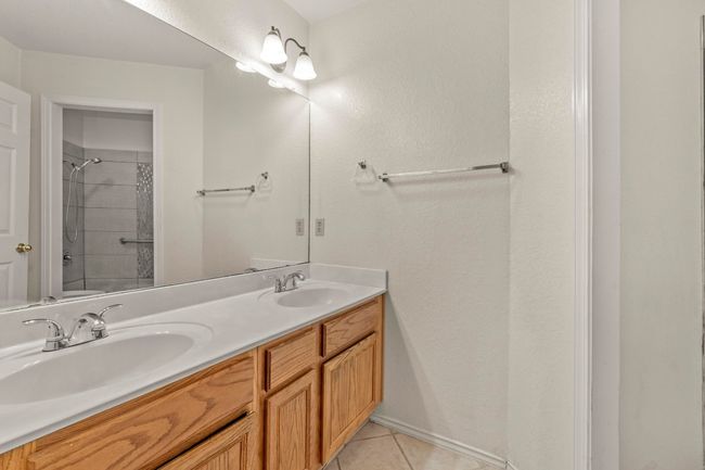 Full hallway bathroom featuring a double vanity & walk-in shower | Image 24