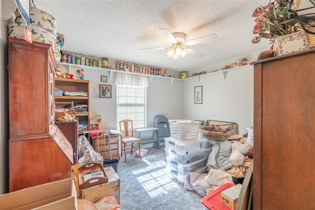 Bedroom with carpet flooring, a textured ceiling, and a ceiling fan | Image 24
