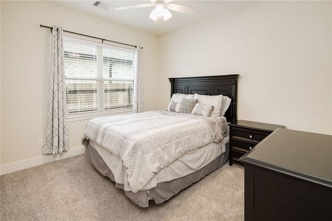Bedroom featuring light carpet, ceiling fan, and baseboards | Image 17