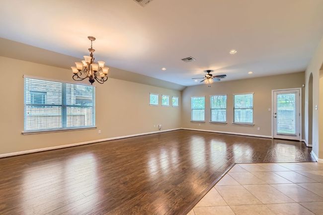 Living and Dining room featuring wood finished floors, a chandelier, ceiling fan, and recessed lighting | Image 7