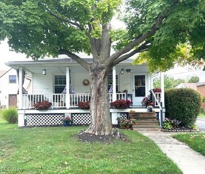 Rear view of property featuring a porch and a lawn | Image 1