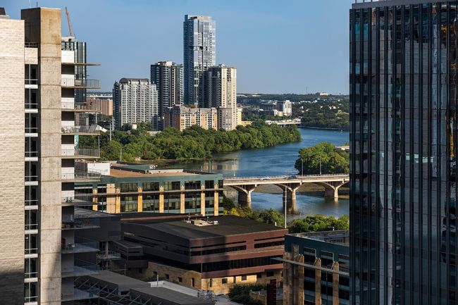 View of city from balcony with a notable bridge and a large body of water | Image 25