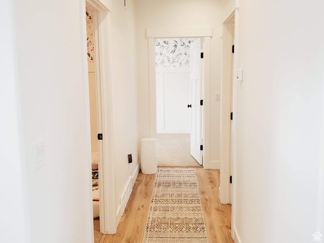 Hall featuring visible vents, baseboards, and wood finished floors | Image 16
