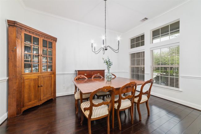 To the right is the formal dining room with wood floors, updated lighting, neutral paint colors and access into the kitchen. | Image 6