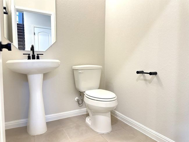 Bathroom featuring toilet, sink, baseboards, and tile floors | Image 7