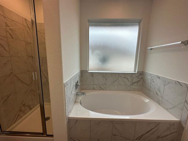 Bathroom featuring a garden tub, a stall shower, and a textured wall | Image 24