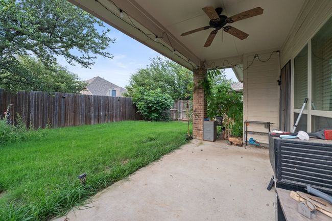 Fenced backyard with a ceiling fan and a patio | Image 28