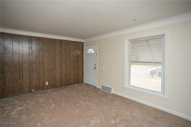 Carpeted entryway featuring wooden walls and baseboards | Image 9