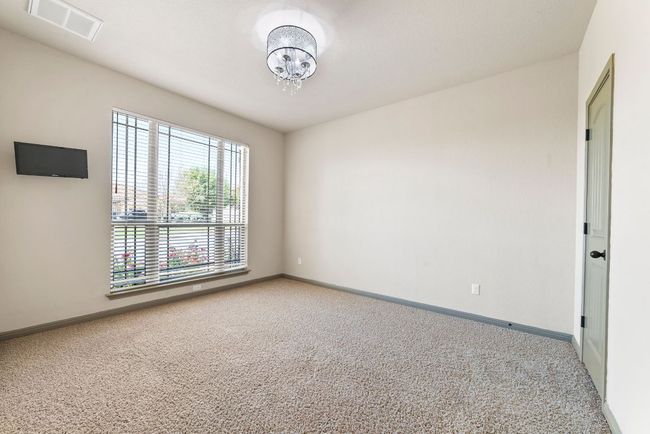 Carpeted spare room with baseboards and a chandelier | Image 9
