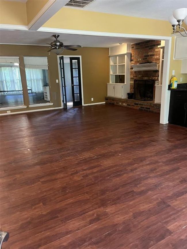Unfurnished living room with a brick fireplace, dark wood finished floors, and a ceiling fan | Image 30