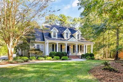 Cape cod-style house with a front lawn and covered porch | Image 1