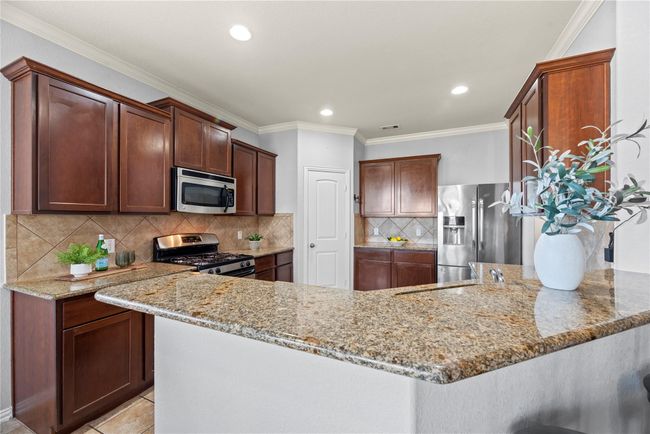 Designed with daily food prep in mind, the gourmet kitchen includes a breakfast bar. Move between chopping organic veggies to stirring the stew, all while keeping an eye on the kiddos. | Image 6