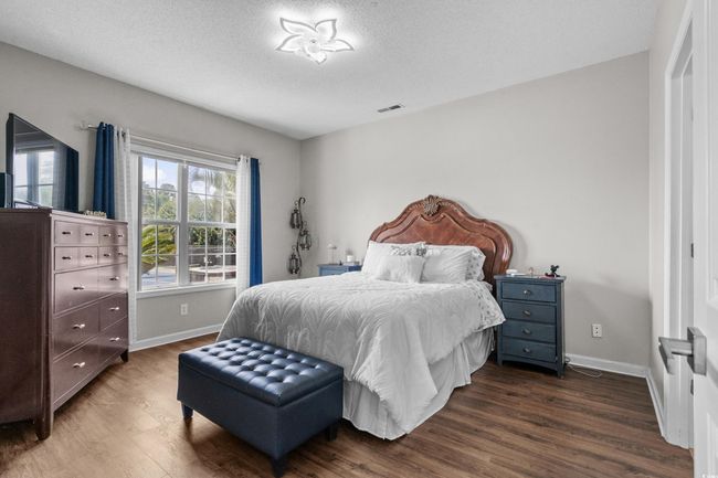 Bedroom featuring dark wood-style floors, baseboards, and a textured ceiling | Image 23