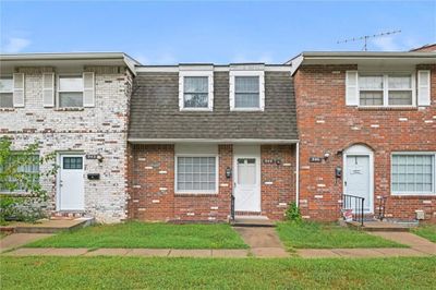 Townhome / multi-family property with a front yard | Image 1