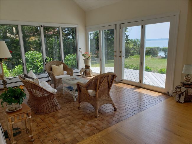 Sunroom / solarium featuring vaulted ceiling, french doors, and a water view | Image 16