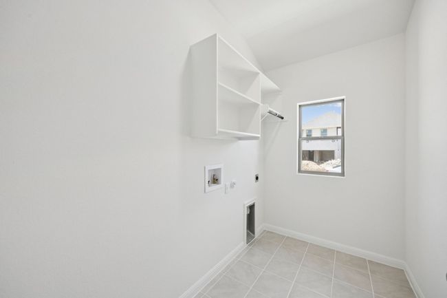 Washroom featuring gas dryer hookup, hookup for an electric dryer, hookup for a washing machine, and light tile patterned floors | Image 32