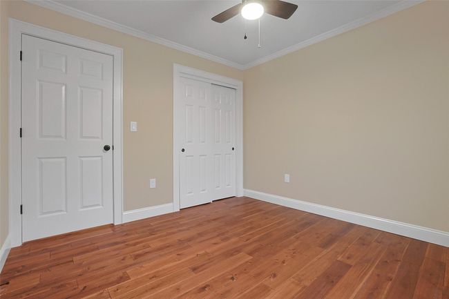 Generous third bedroom with double closet, ceiling fan and ornamental molding. | Image 31