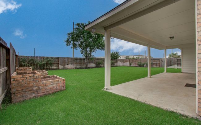 Private back yard has a large covered patio. | Image 32