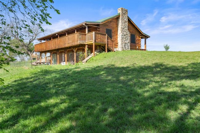 Rear view of property with a chimney, a yard, a deck, and log exterior | Image 7